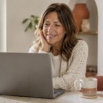Woman in her fifties on a laptop video consultation with a menopause specialist from home