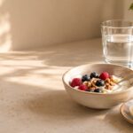 A nourishing perimenopause breakfast: yogurt with berries, walnuts, a boiled egg and a glass of water