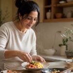 Woman in a warm kitchen plating a protein breakfast of eggs and salmon